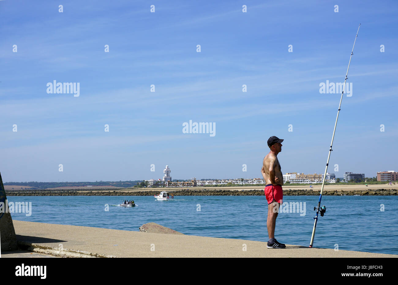 Pêcheur pêcheur en short rouge Pêche en mer Espagne Costa del la Luz Isla Canela Banque D'Images