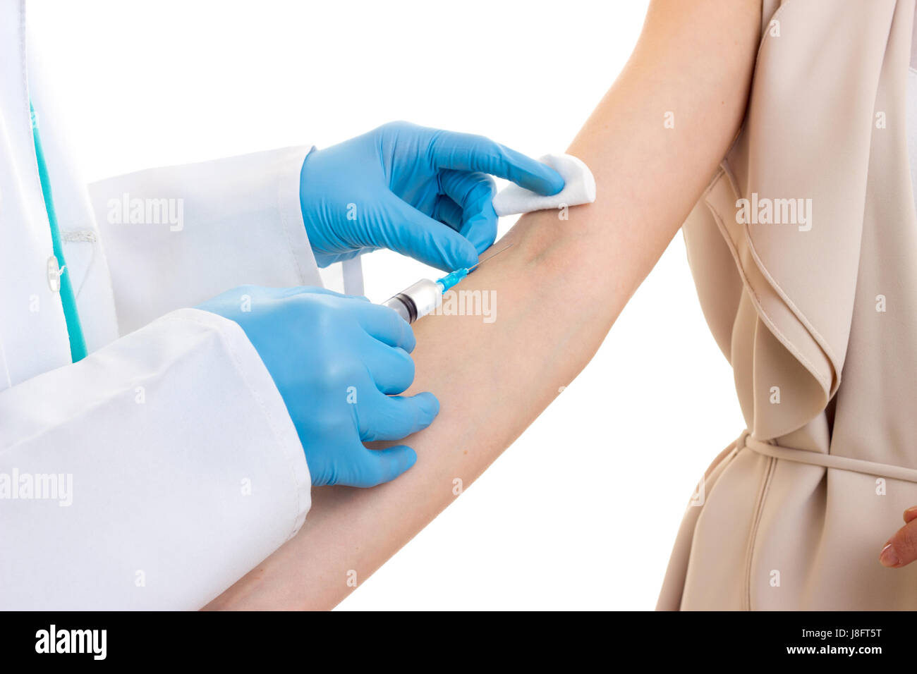 Médecin homme en robe blanche avec stéthoscope et gants bleu faire une injection de jeune femme en blouse beige sur fond blanc en studio Banque D'Images