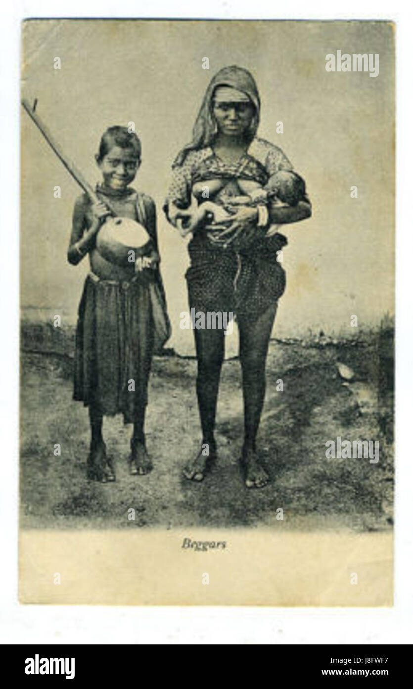 Une photographie de 1910 représentant des mendiants indiens, montrant une femme et un enfant avec un instrument de musique. L'image met en évidence les conditions sociales et économiques de l'époque en Inde au début du XXe siècle. Banque D'Images