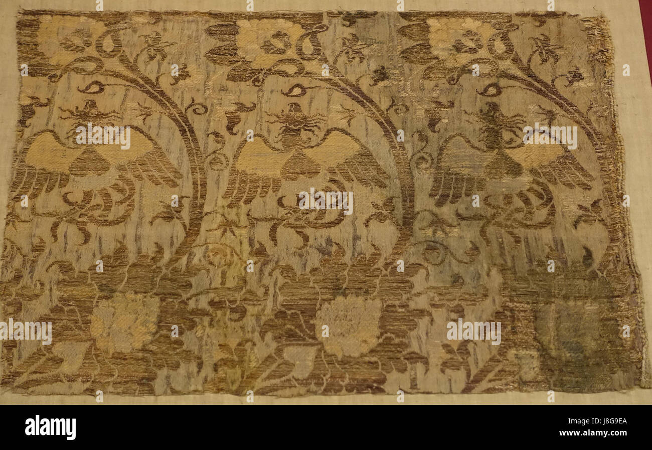 Ce fragment textile Lampas du XIVe siècle originaire d'Italie est fabriqué à partir de soie avec une double couche de fil d'or. C'est un exemple exquis de l'art textile médiéval, mettant en valeur l'habileté et l'art des tisserands italiens de l'époque. Banque D'Images