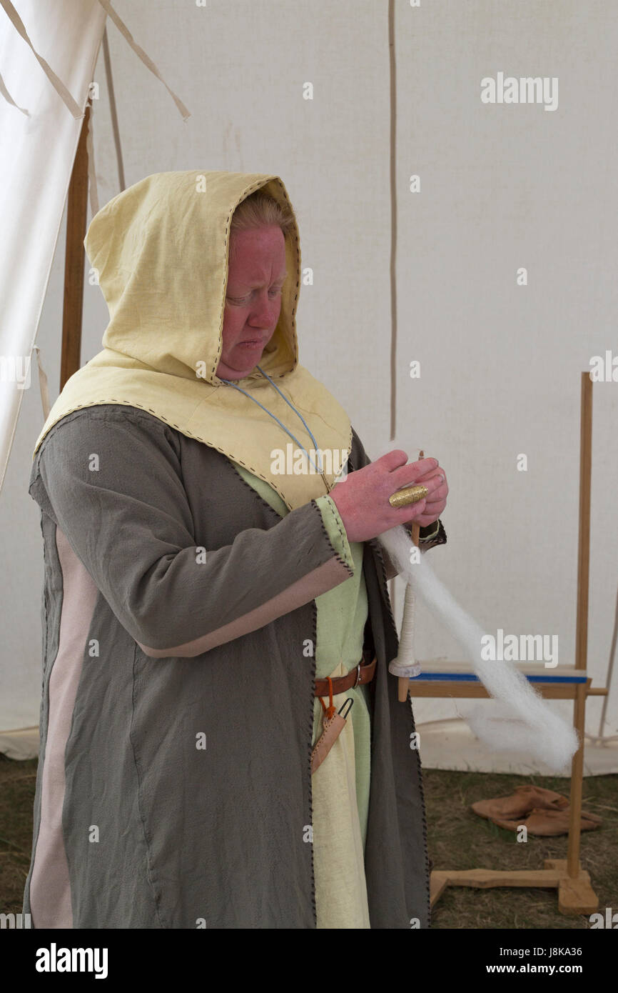 Femme en costume traditionnel filage de la laine dans la tente à réplique de colonie viking Banque D'Images
