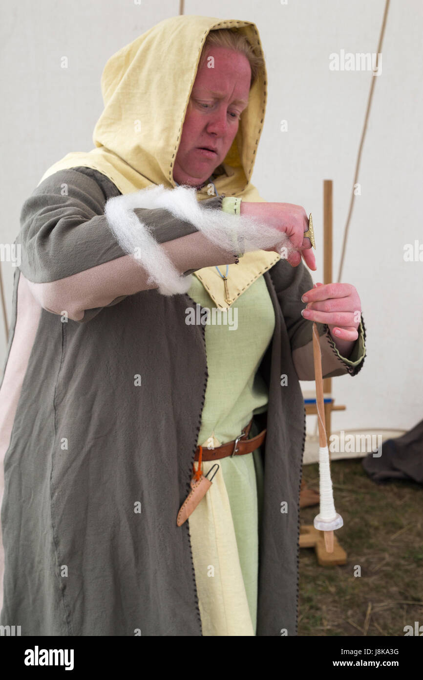 Femme en costume traditionnel filage de la laine dans la tente à réplique de colonie viking Banque D'Images