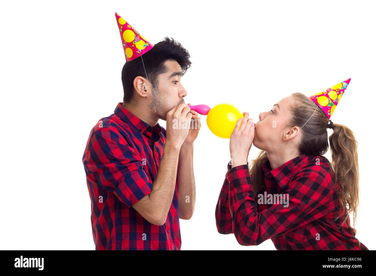 Jeune couple blowing balloons Banque D'Images