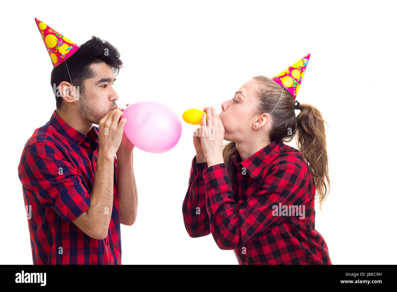 Jeune couple blowing balloons Banque D'Images