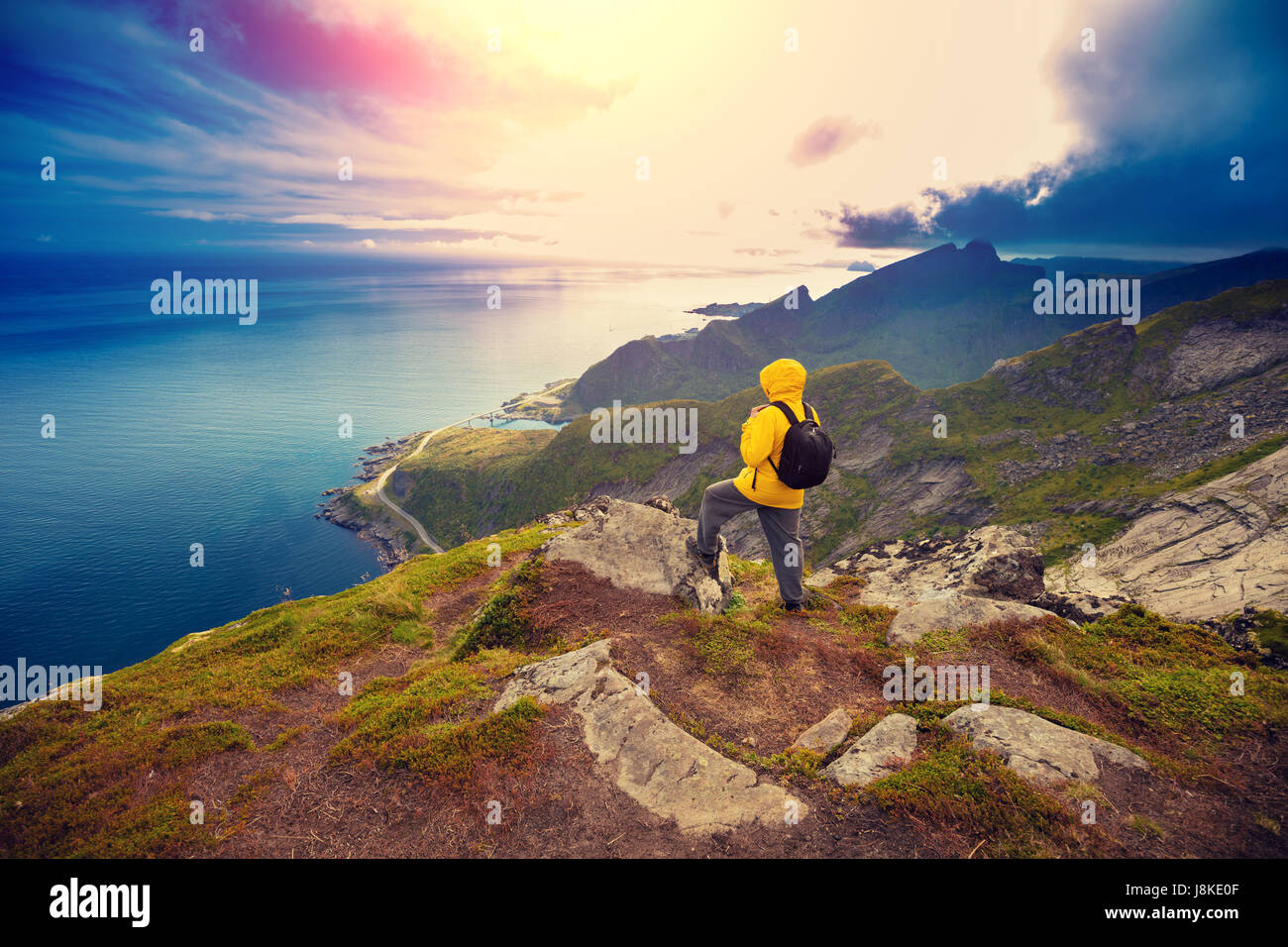 Vue panoramique du fjord et village de pêcheurs. L'homme debout sur une falaise de roche. Magnifique paysage de montagne. Nature de la Norvège, îles Lofoten Banque D'Images