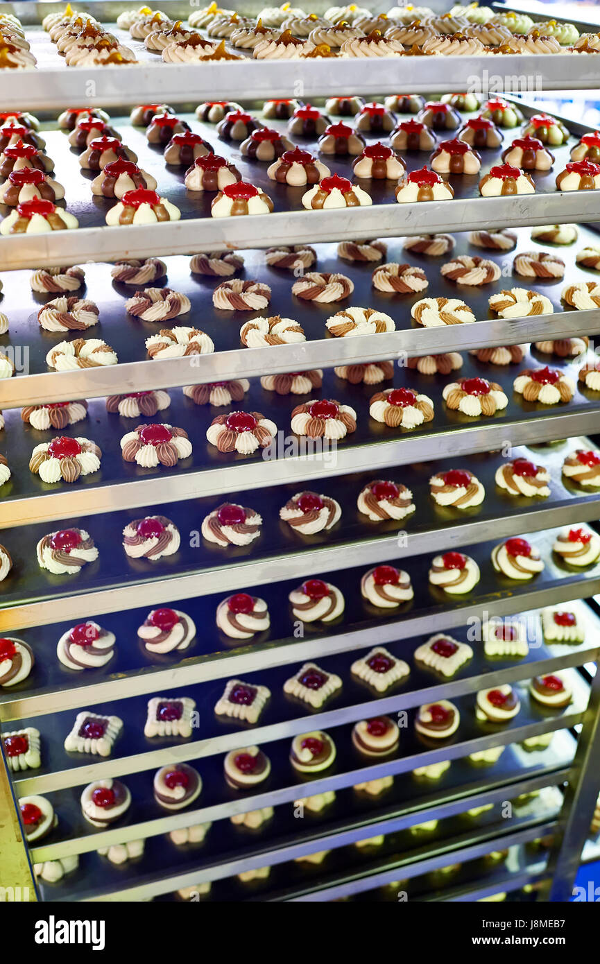 Biscuits et Gâteaux sur des étagères métalliques dans une usine de confiserie Banque D'Images