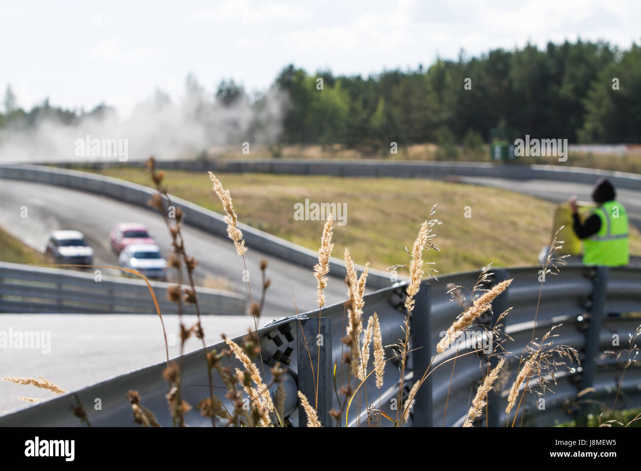 Course de rallye-cross et de glissières de sécurité, l'accent sur l'herbe sèche sur l'arrière-plan des voitures Banque D'Images