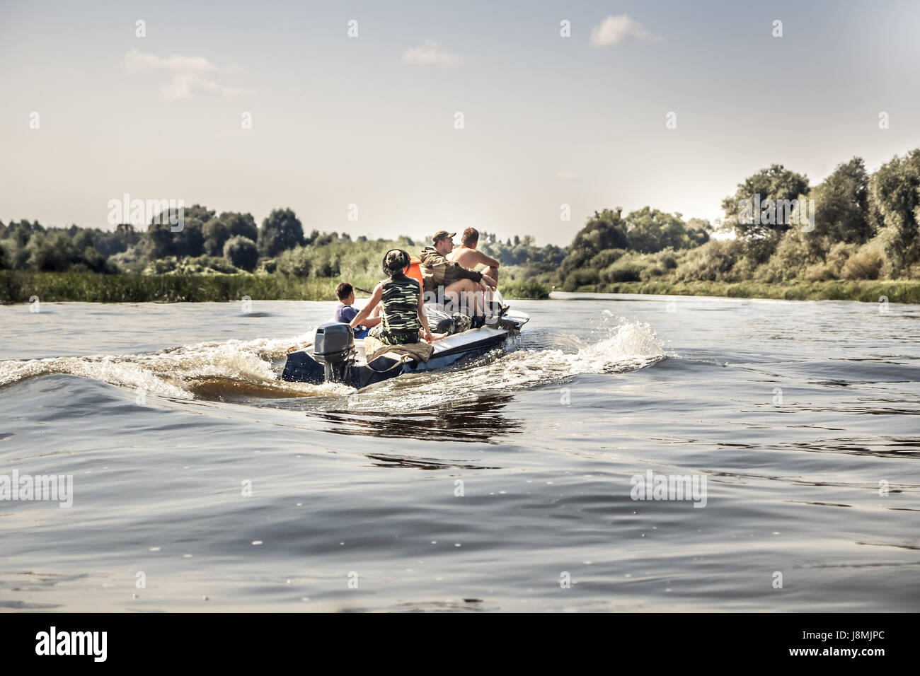 Groupe d'hommes de la voile sur le bateau à moteur par la rivière en été, jour du camping pendant la saison de la chasse Banque D'Images