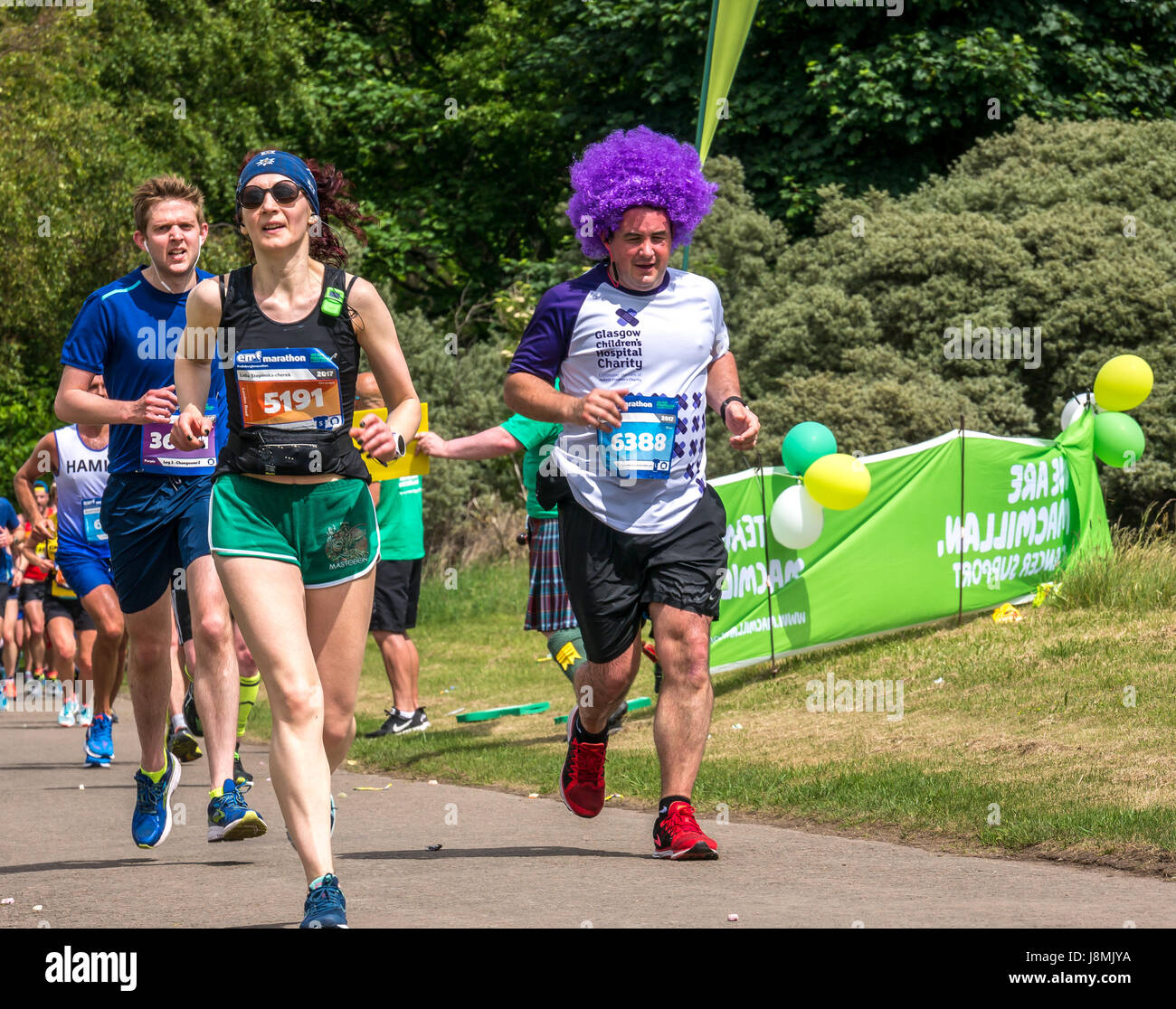 Porteur dans l'Edinburgh Festival Marathon 2017 à Gosford Estate, East Lothian, Scotland, UK au Mile 18, avec l'homme en marche pour la charité en perruque violette Banque D'Images