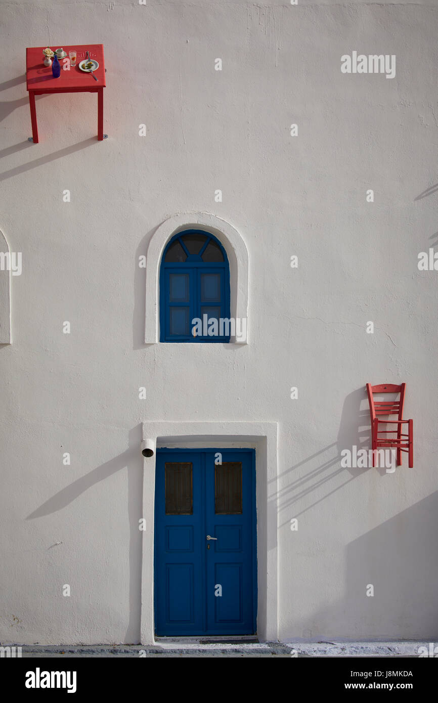 L'île volcanique de Santorin, l'une grecque des Cyclades dans la mer Égée. Restaurant d'Oia avec table et chaise collée au mur comme une fonction Banque D'Images