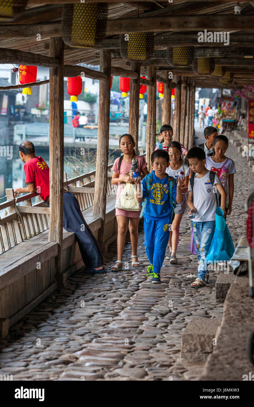 Yantou, Yongjia, Zhejiang, Chine. Les écoliers à marcher le long de la rue Shanghai. Banque D'Images
