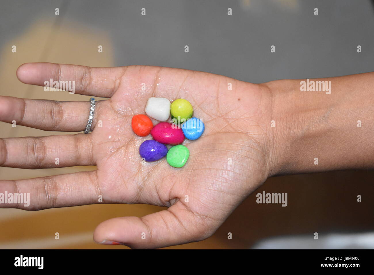 Cailloux colorés placés sur palm Banque D'Images