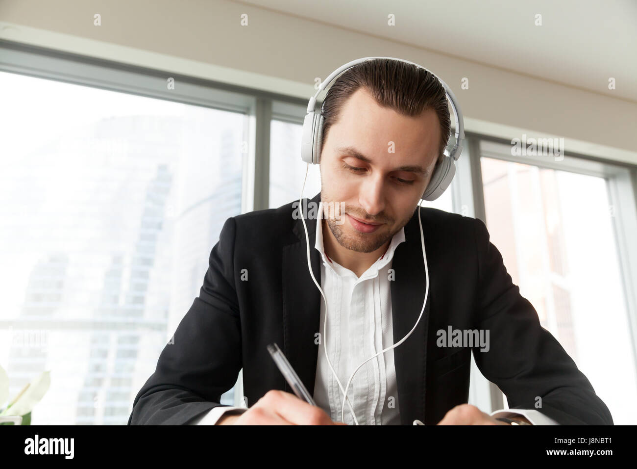 L'homme à l'écriture avec un casque à plume bureau Banque D'Images