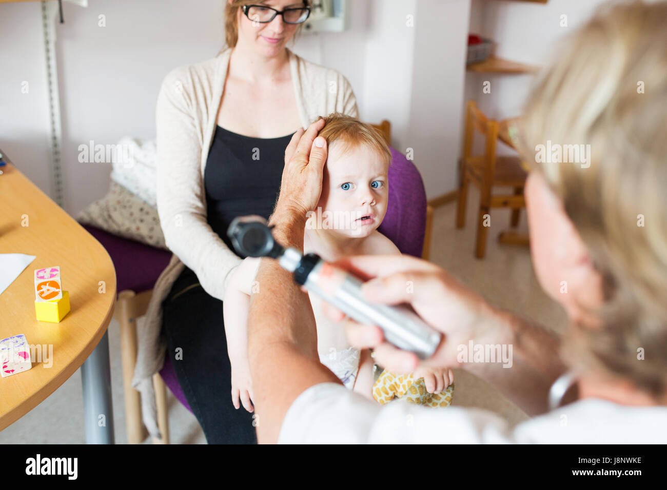 Baby (12-17 mois) avec la mère et le médecin de salle d'examen Banque D'Images