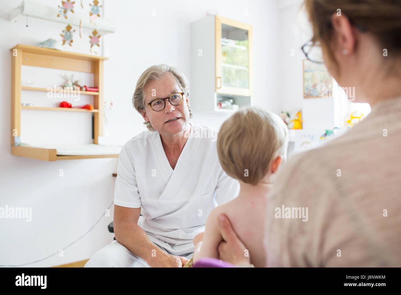 Baby (12-17 mois) avec la mère et le médecin de salle d'examen Banque D'Images