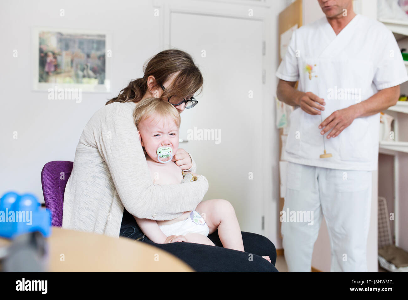 Baby (12-17 mois) avec la mère et le médecin de salle d'examen Banque D'Images