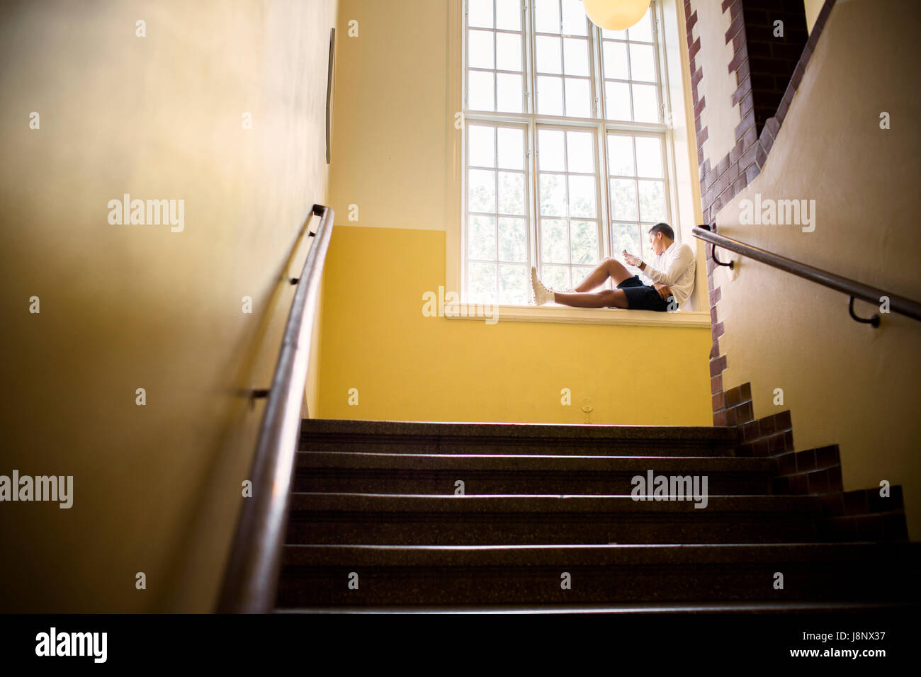 Étudiant (14-15) sitting by window Banque D'Images
