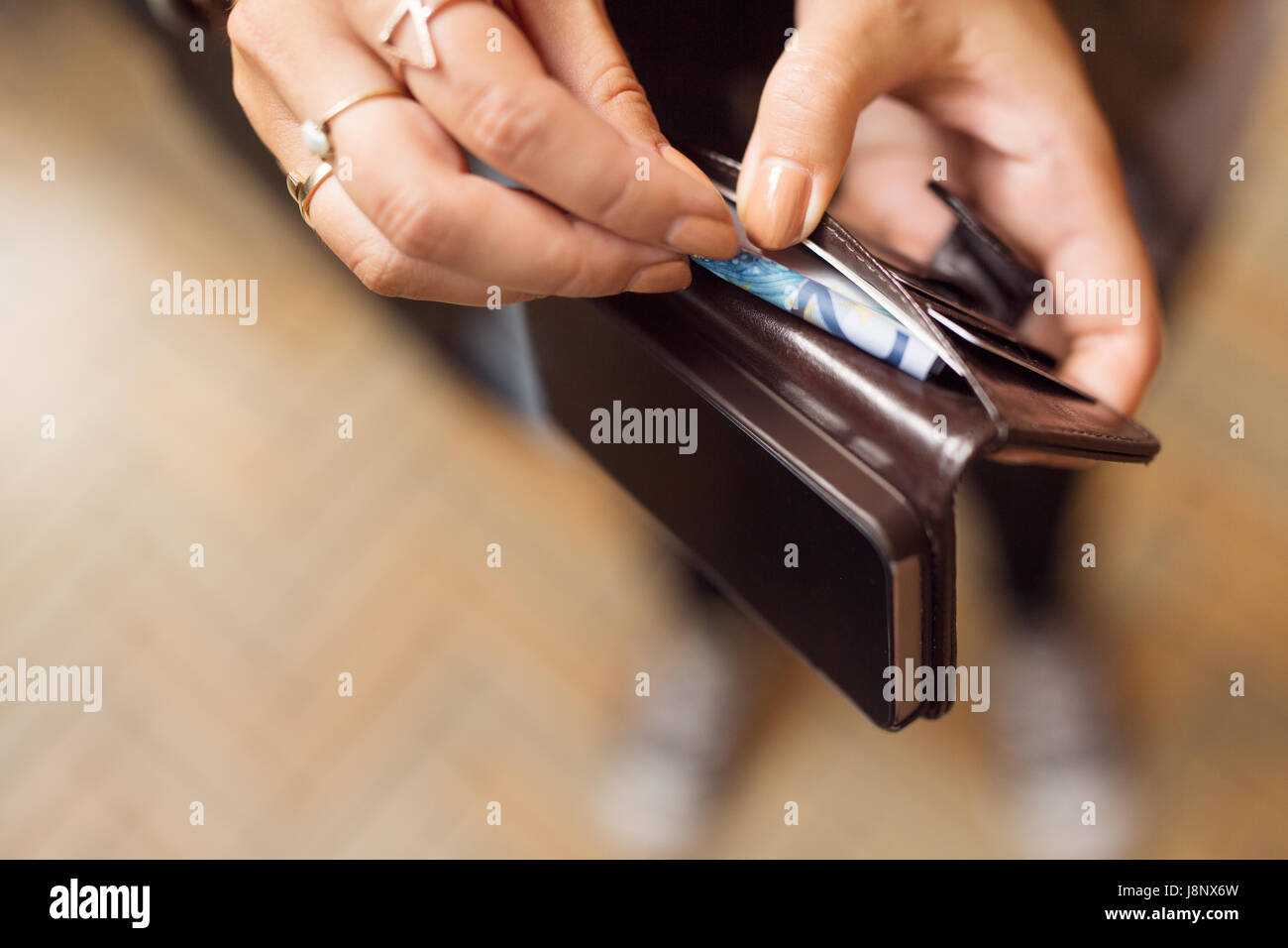 La tenue d'une femme avec porte-monnaie et billets cell phone Banque D'Images