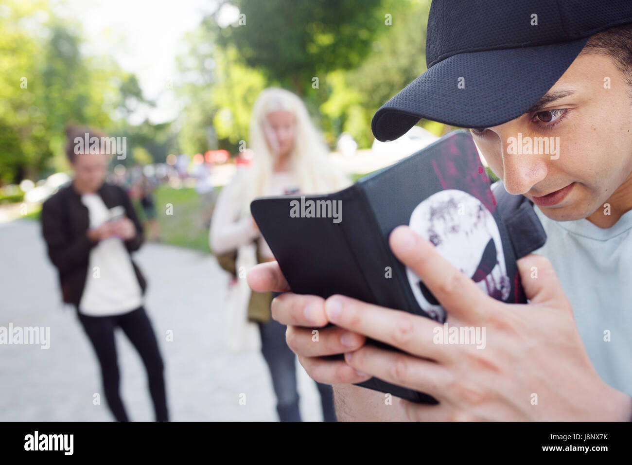 Groupe d'amis qui jouent le jeu de la réalité augmentée avec les téléphones mobiles Banque D'Images