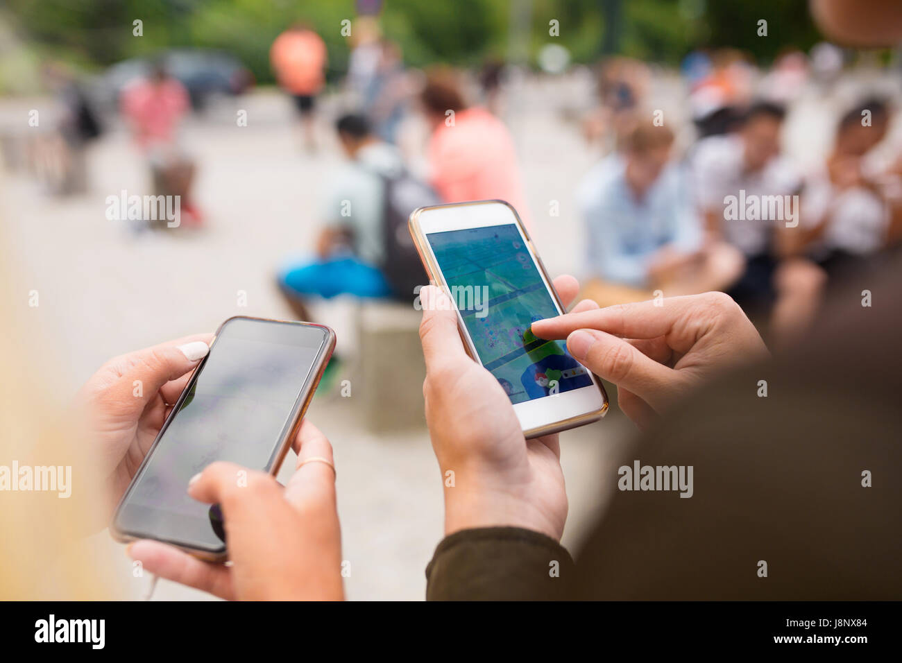 Les personnes jouant le jeu de la réalité augmentée avec les téléphones mobiles Banque D'Images