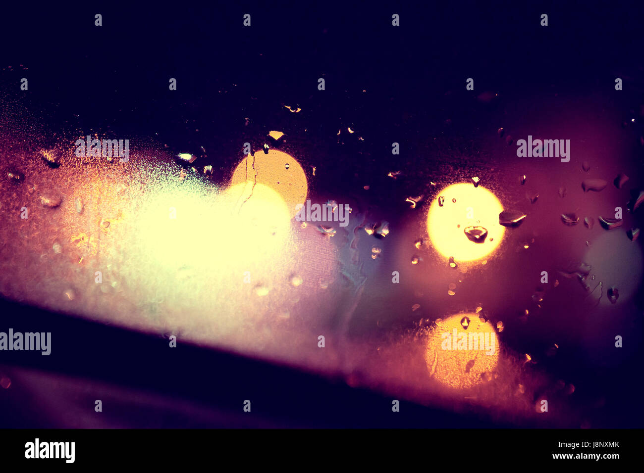 Arrière-plan de la fenêtre humide et les lumières de la ville.Rainny nuit à travers la vitre Banque D'Images