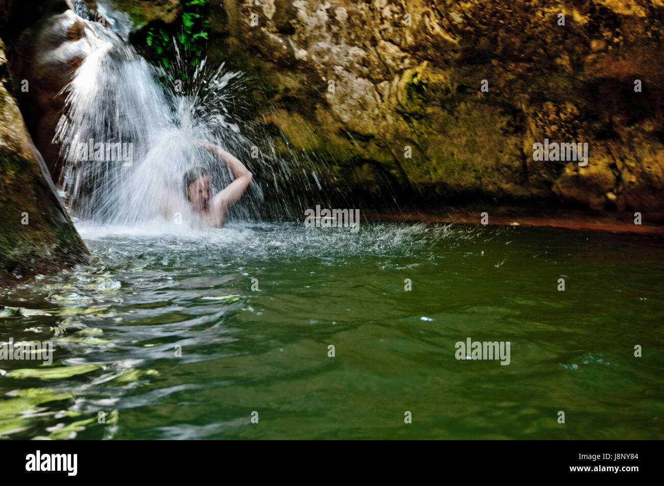 Echelle de l'homme under waterfall Banque D'Images