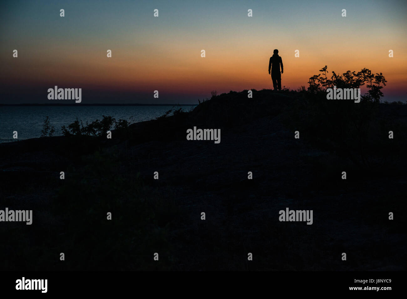 Silhouette of man au coucher du soleil Banque D'Images