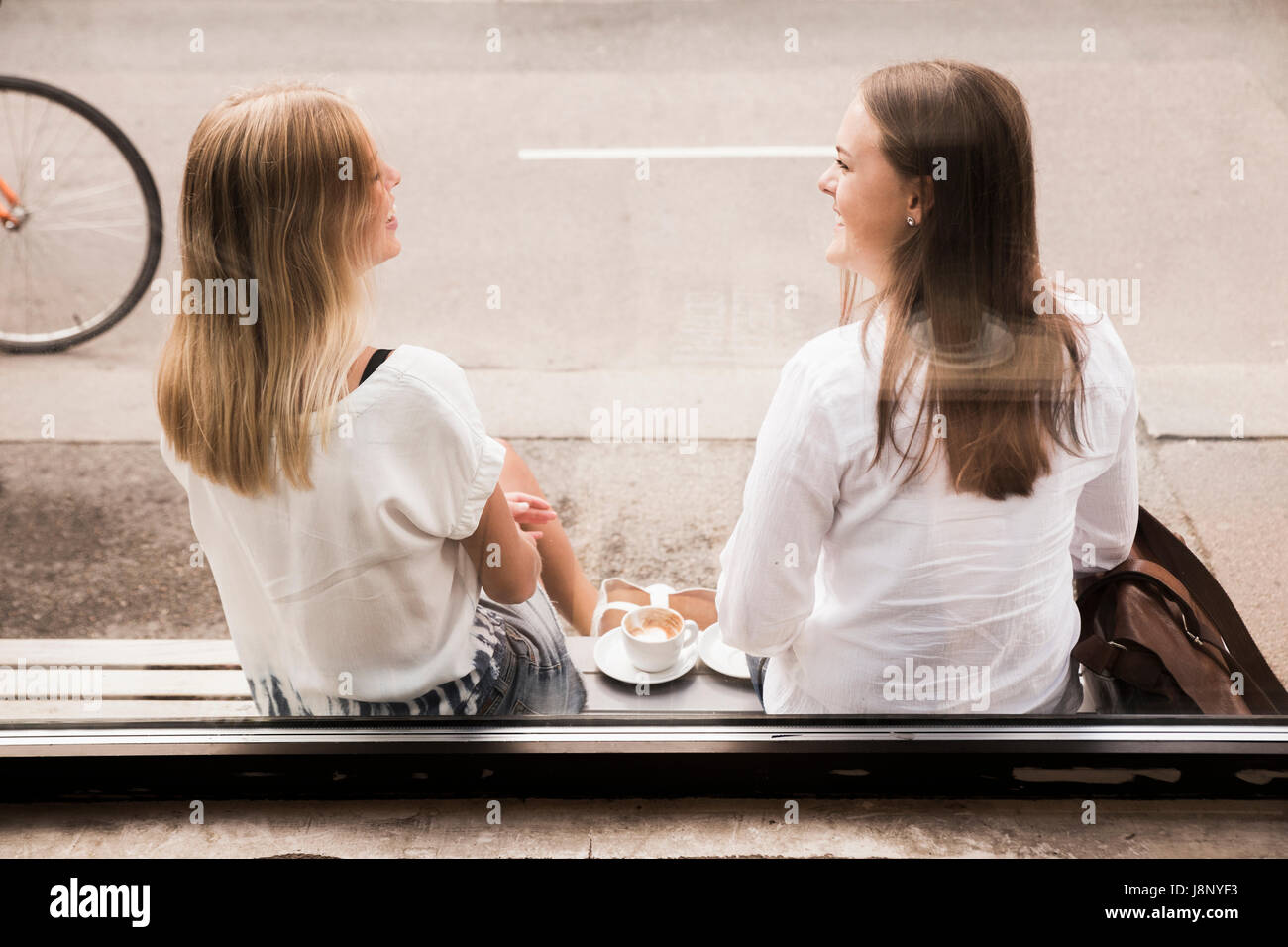 Les jeunes femmes parle en dehors de cafe Banque D'Images
