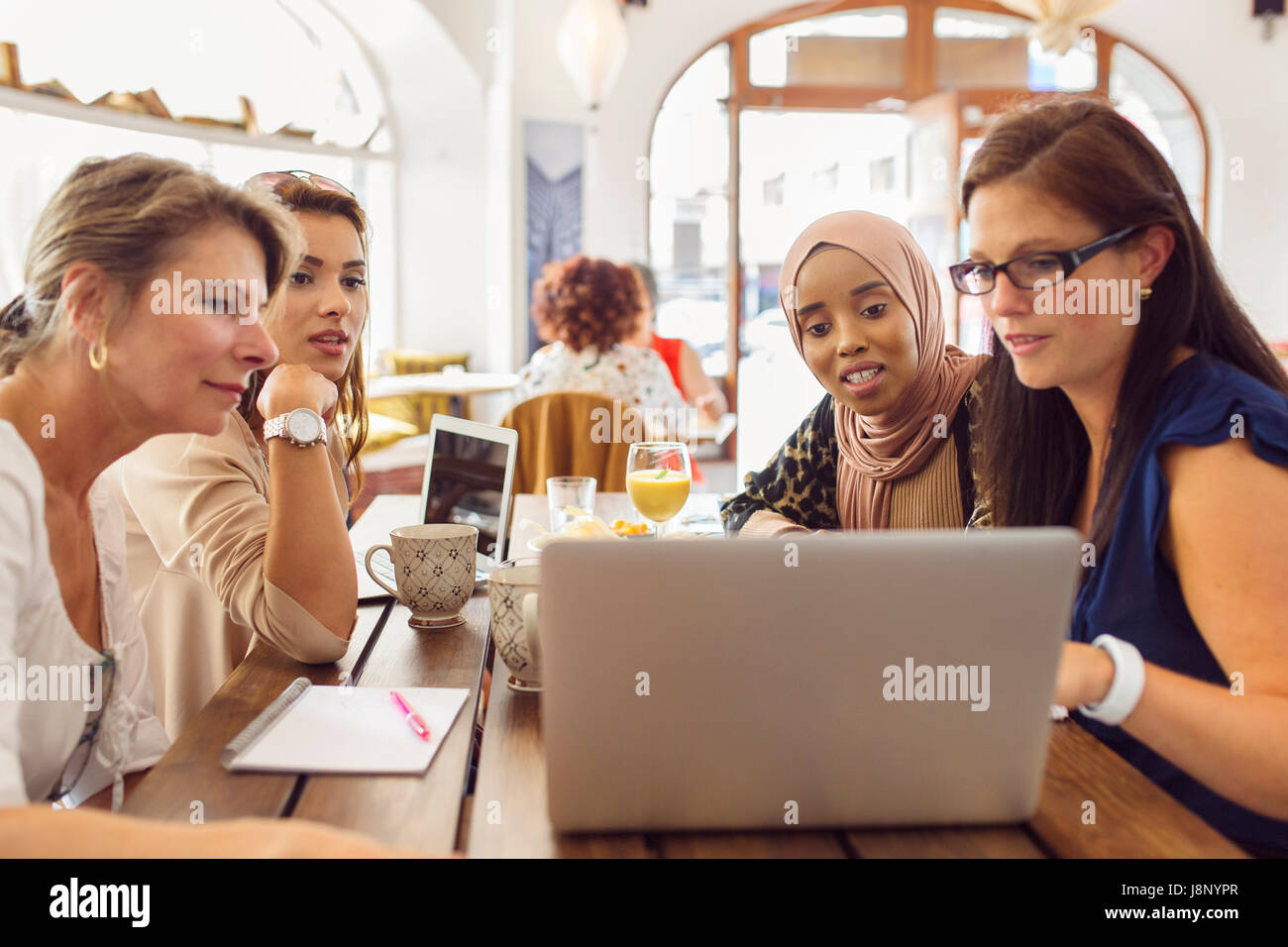 Businesswomen using laptop pendant le déjeuner au restaurant Banque D'Images