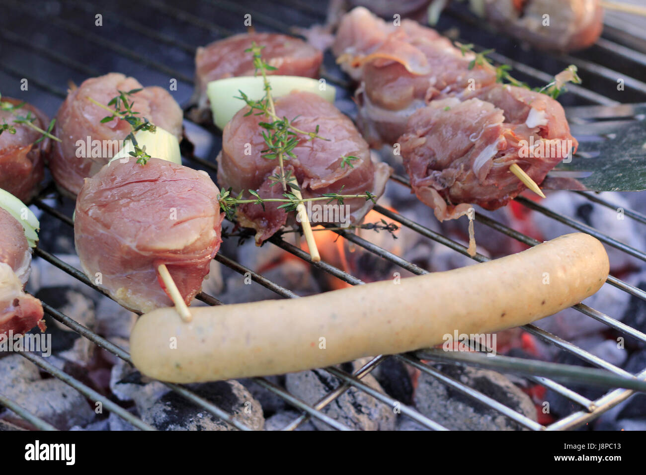 Brochettes et une saucisse sur le grill Banque D'Images