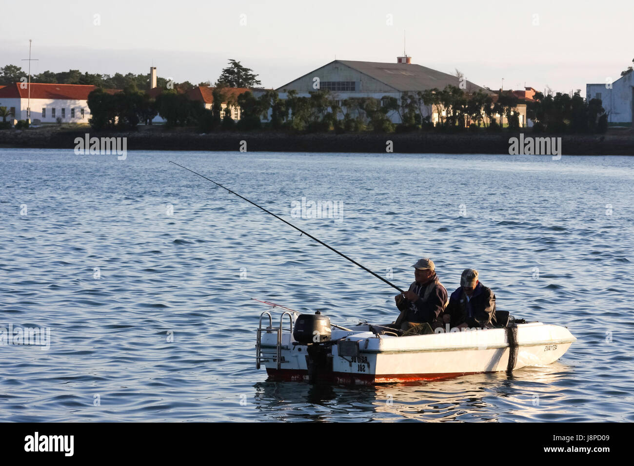 Deux hommes dans un petit bateau de pêche à Aveiro, Portugal. Banque D'Images