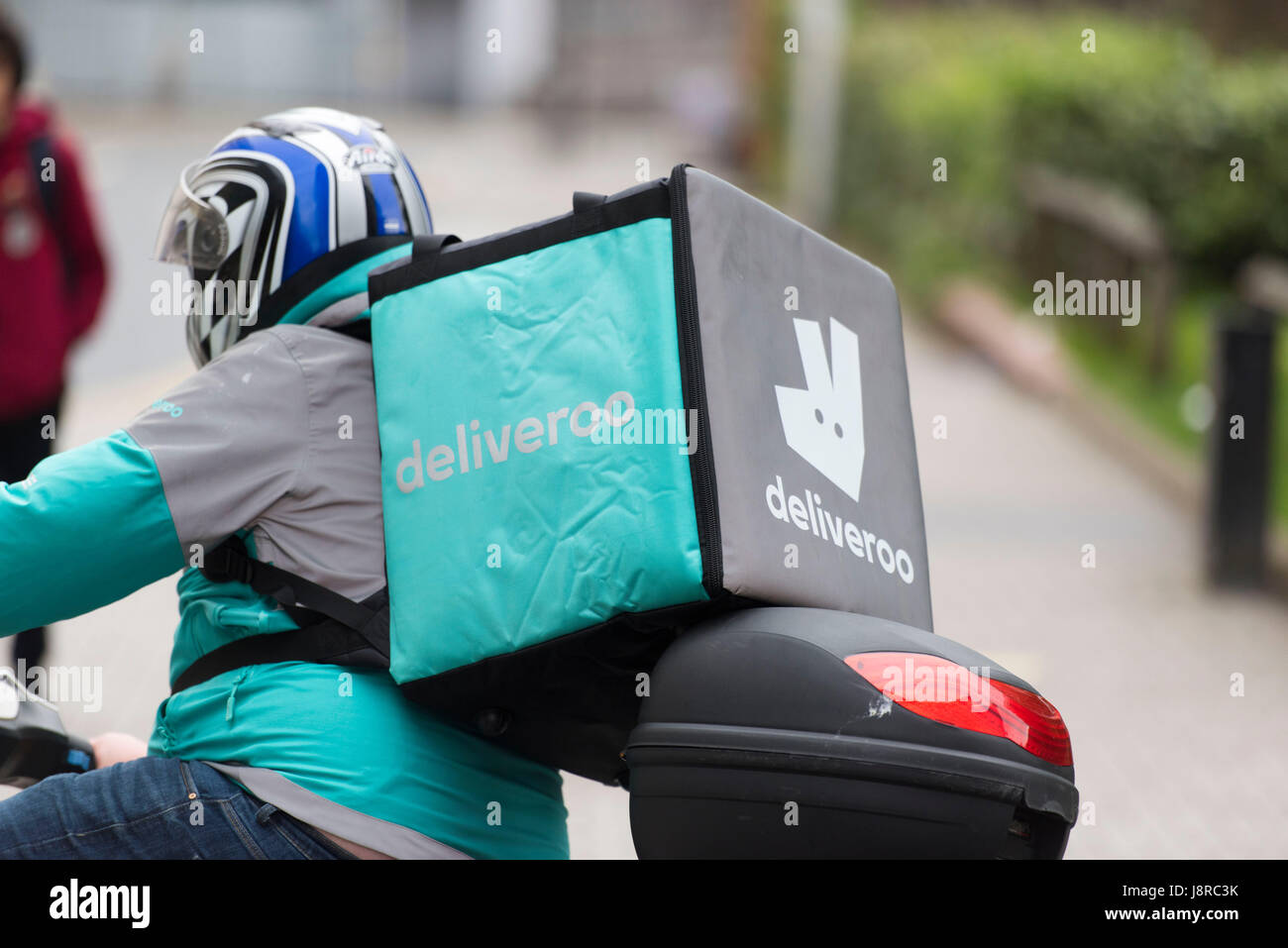 Un Deliveroo rider sur un cyclomoteur faisant une livraison de nourriture à Cardiff, Pays de Galles, Royaume-Uni. Banque D'Images