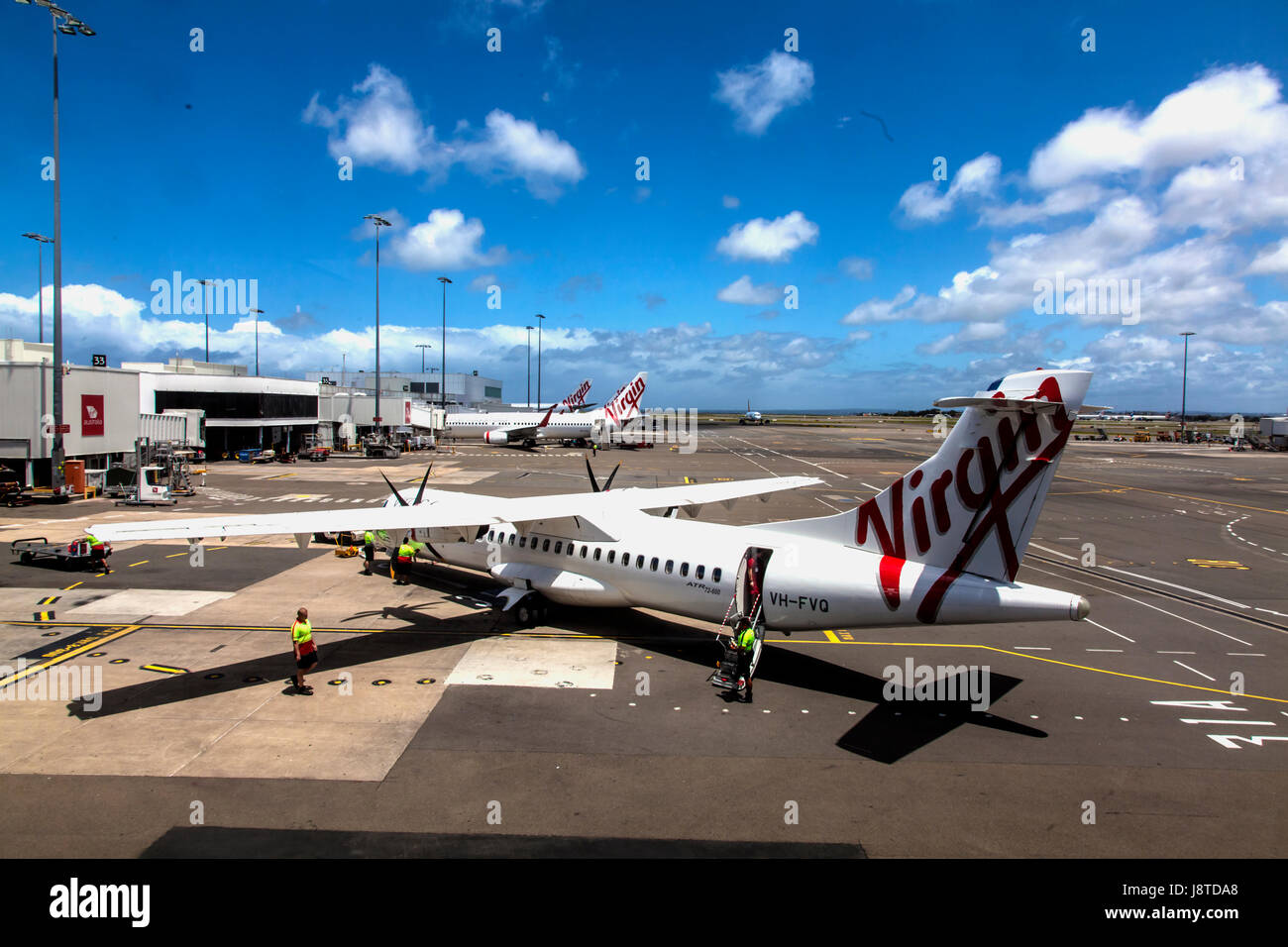 Virgin Australia personnel au sol travaillant sur jet avant le décollage à l'aéroport de Sydney Banque D'Images