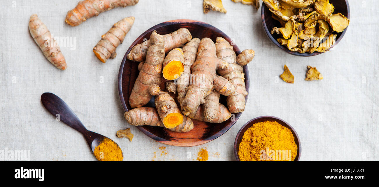 Les racines de curcuma frais et séchés dans un bol en bois Banque D'Images