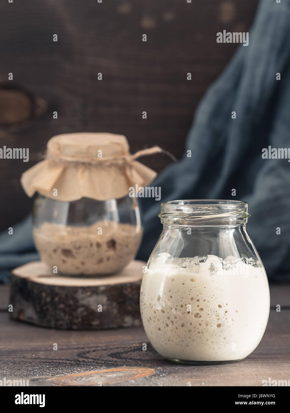 Le blé et le seigle Active levain dans un bocal en verre sur fond de bois brun. Démarreur pour pain au levain. La tonalité de l'image. Copier l'espace. La verticale Banque D'Images
