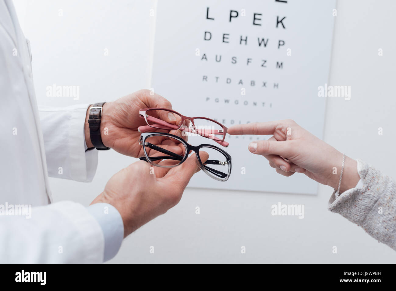 Femme choix d'une paire de lunettes après l'examen des yeux, l'opticien est de lui donner un conseil Banque D'Images