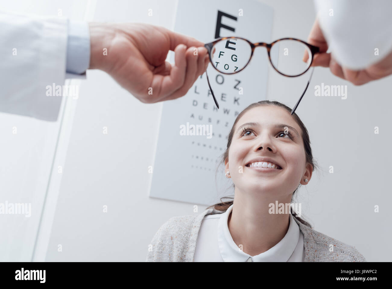Jeune femme heureuse d'essayer sa nouvelle paire de lunettes après l'examen des yeux Banque D'Images