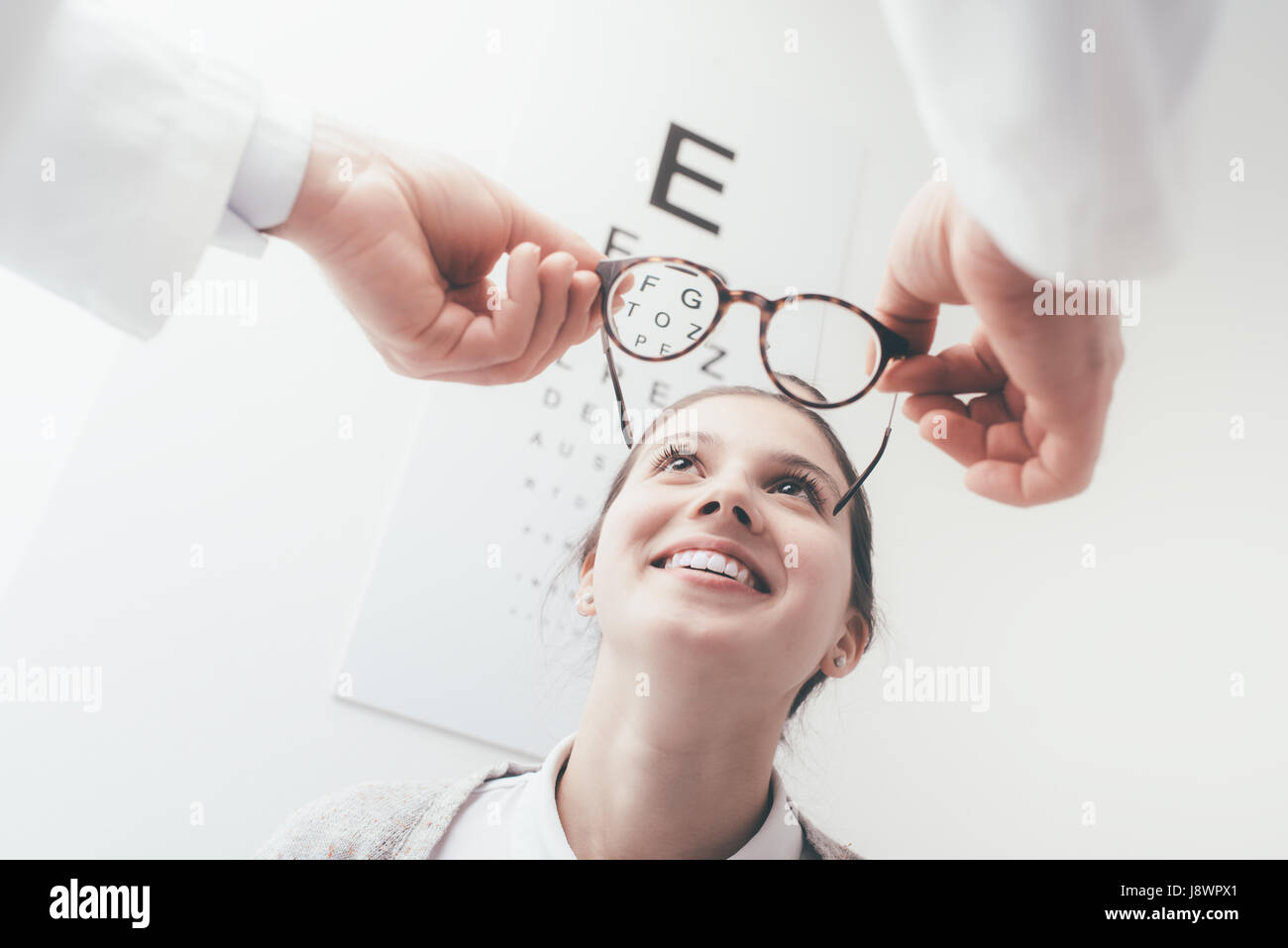 Jeune femme heureuse d'essayer sa nouvelle paire de lunettes après l'examen des yeux Banque D'Images