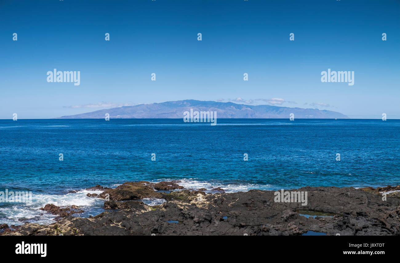 Vue panoramique de l'île de La Gomera vu de la côte ouest de Tenerife sur un matin clair, Playa San Juan, Îles Canaries, Espagne Banque D'Images