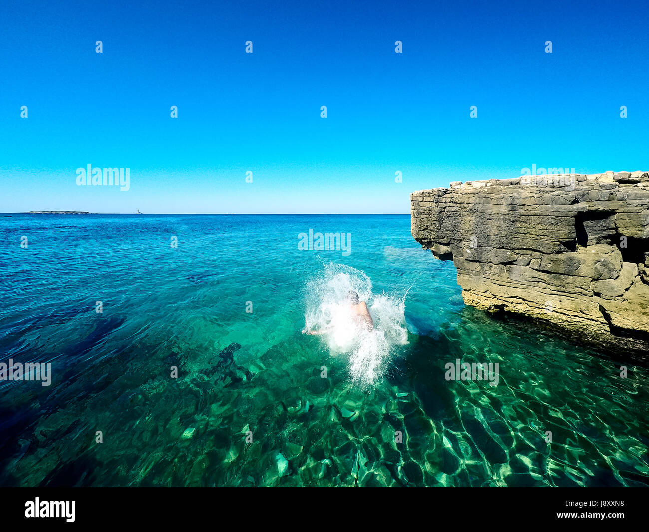 Heureux garçon sautant dans la mer croate Banque D'Images