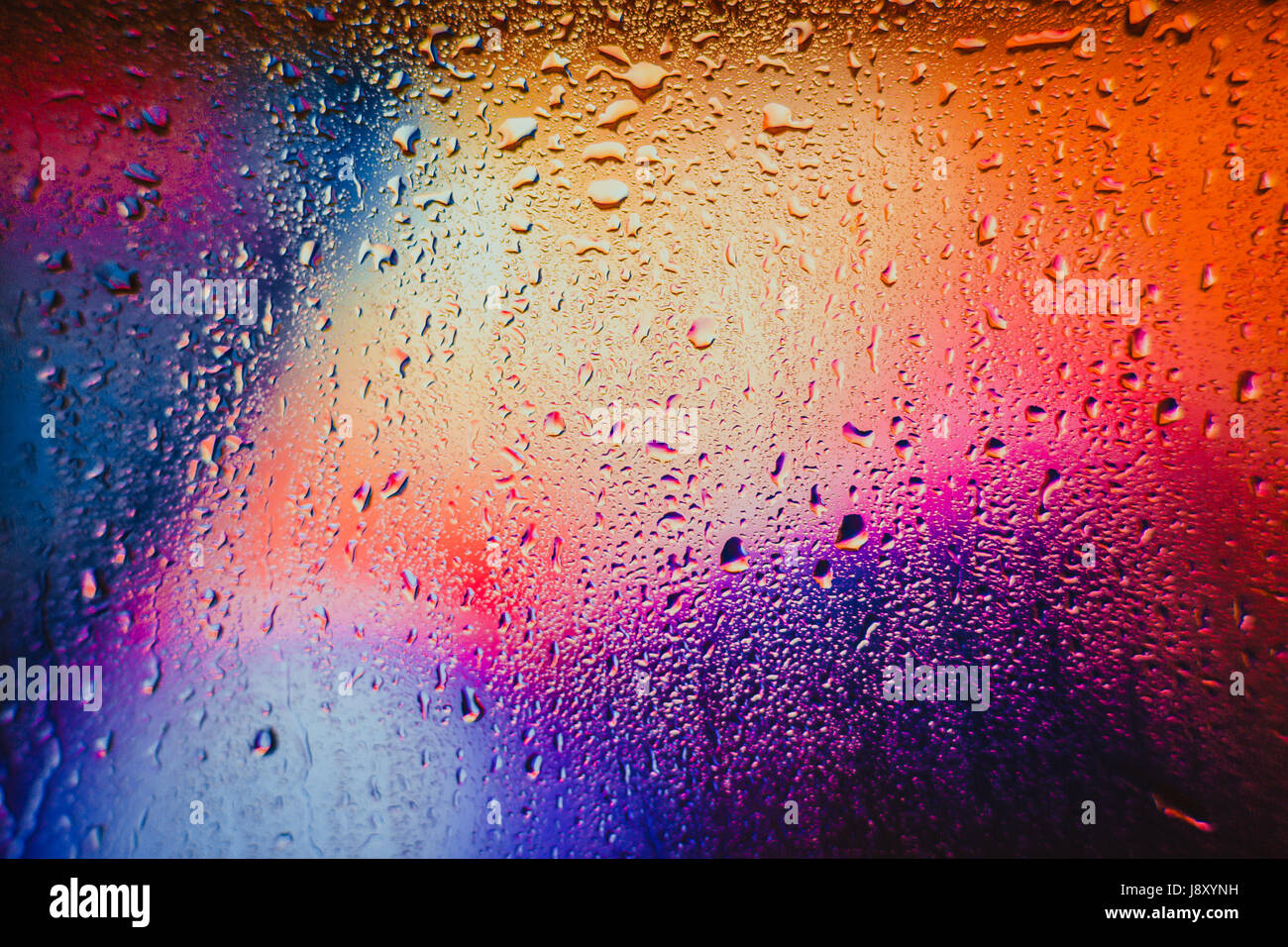 Gouttes de pluie sur un fond multicolore brouillée. Banque D'Images