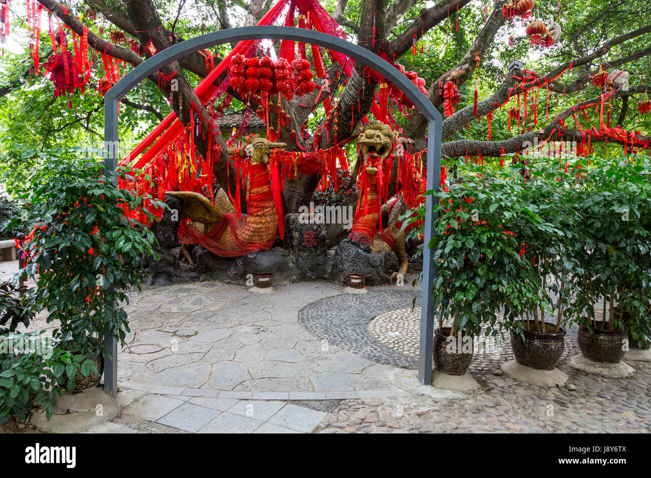Guilin, Chine. Elephant Trunk Hill Park. Rubans rouges accrochés sur arbre, demandant un souhait pour la nouvelle année. Phoenix chinois dans le centre. Banque D'Images