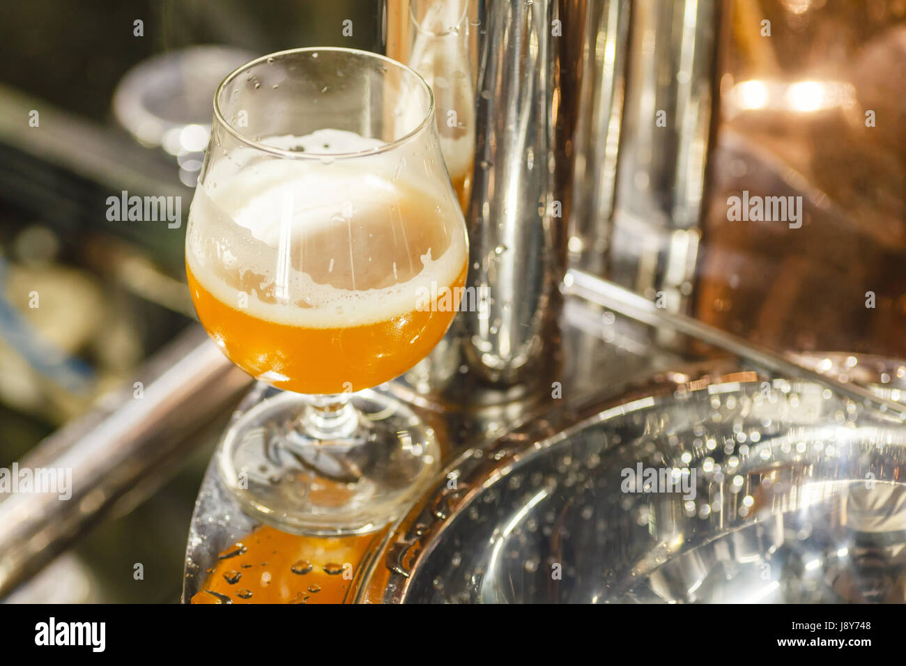 Verre de bière de blé sur le brassage permanent de l'équipement à une brasserie Banque D'Images