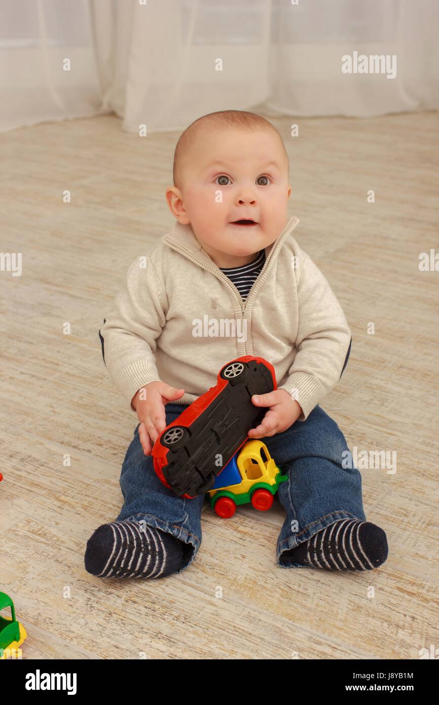 Mignon Bébé Garçon jouant avec des jouets dans la salle de séjour Banque D'Images