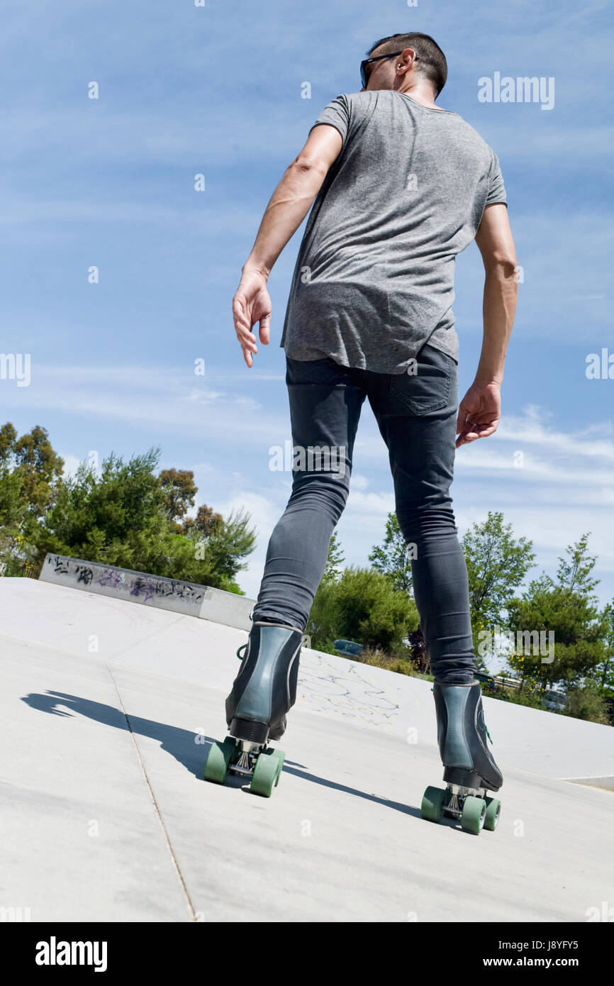 Un jeune homme de race blanche de roller en arrière avec quad skates