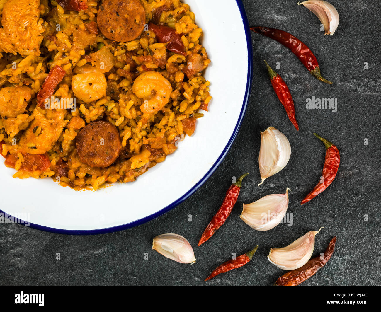 Chorizo fumé poulet langoustines et repas paella contre un arrière-plan en ardoise noire Banque D'Images