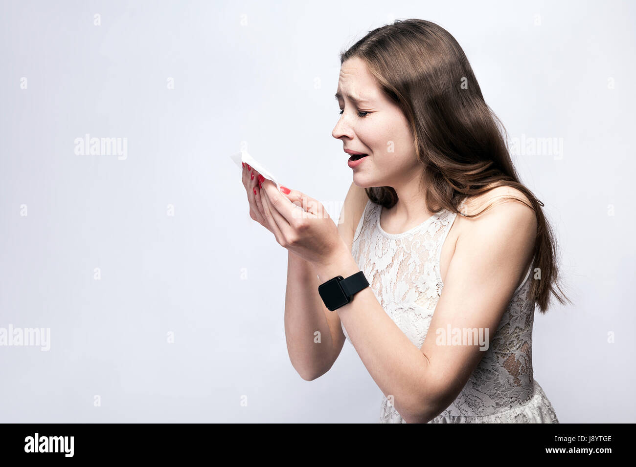 Portrait de femme froide malade avec des taches de rousseur et robe blanche et smart watch sur fond gris argent. santé et médecine concept. Banque D'Images