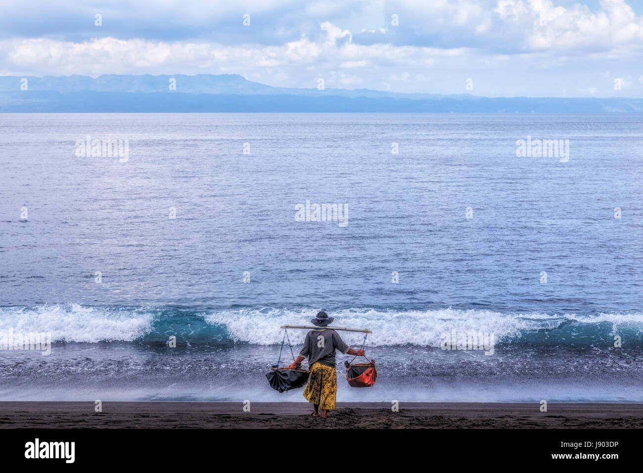 Une femme obtenir de l'eau de la mer, Pantai Belatung, Bali, Indonésie, Asie Banque D'Images