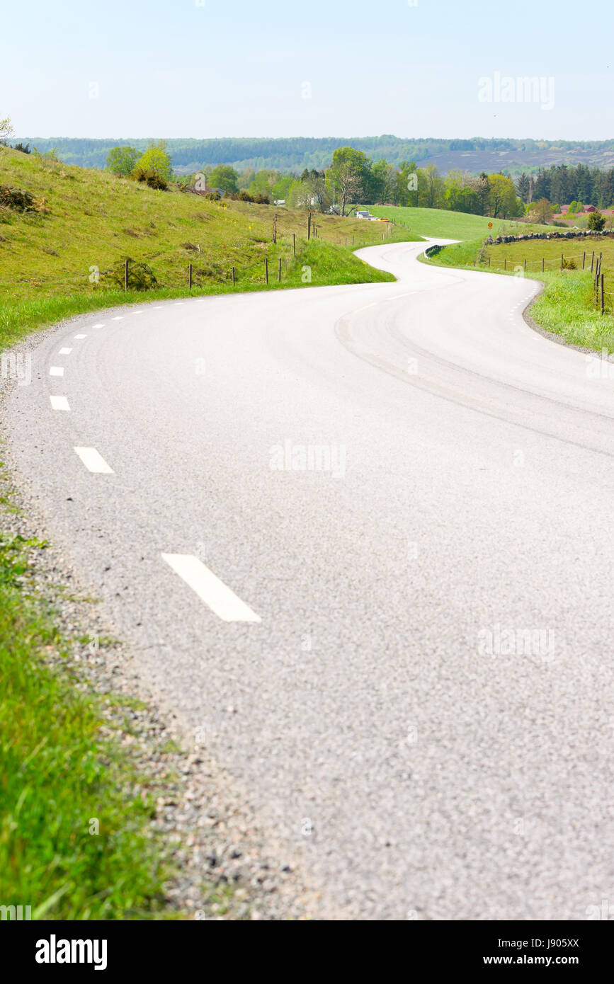 La route serpente à travers le paysage pittoresque. Hills et de prairies le long de la route sinueuse. Lieu Brosarp dans Scania, la Suède. Copie de l'espace sur la route. Banque D'Images