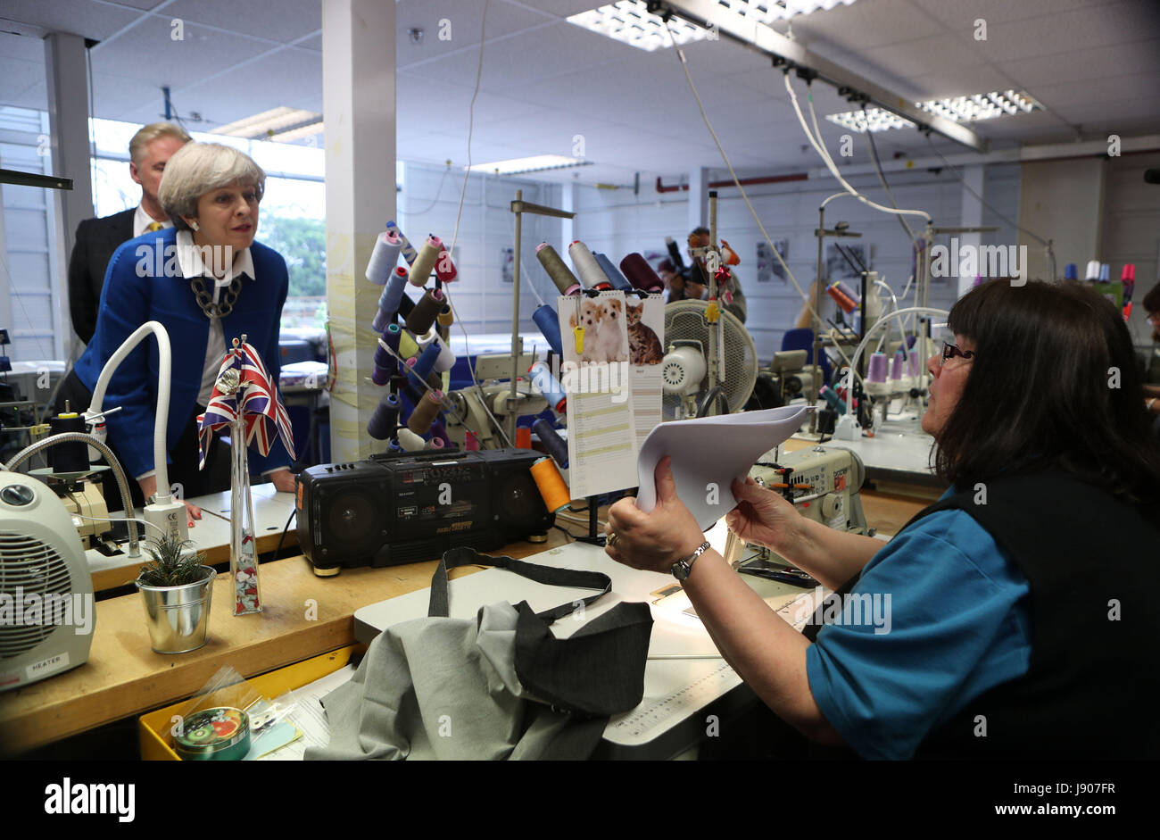 Premier ministre Theresa peut parle de machiniste échantillon Susan Howarth sur une campagne électorale générale visite à Simon Jersey, une entreprise fournisseur d'uniformes à Accrington, Lancashire. Banque D'Images